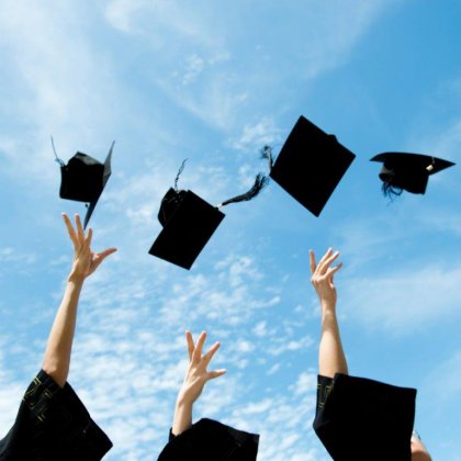 Graduates throwing trencher caps. 